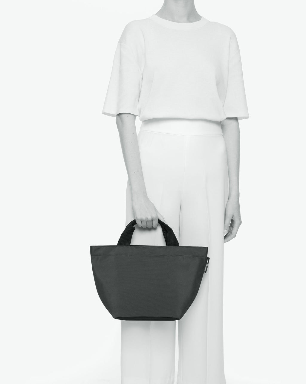 Sac à main cabas de couleur en nylon bicolore, à fond carré et dans un format M. Présence d'un double zip, de poignées courtes noires en polypropylène, et d'une étiquette de marque verte.