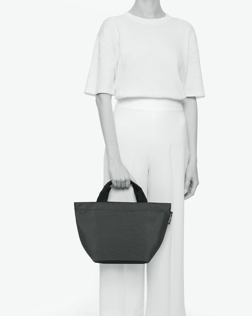 Sac à main cabas de couleur en nylon bicolore, à fond carré et dans un format M. Présence d'un double zip, de poignées courtes noires en polypropylène, et d'une étiquette de marque verte.