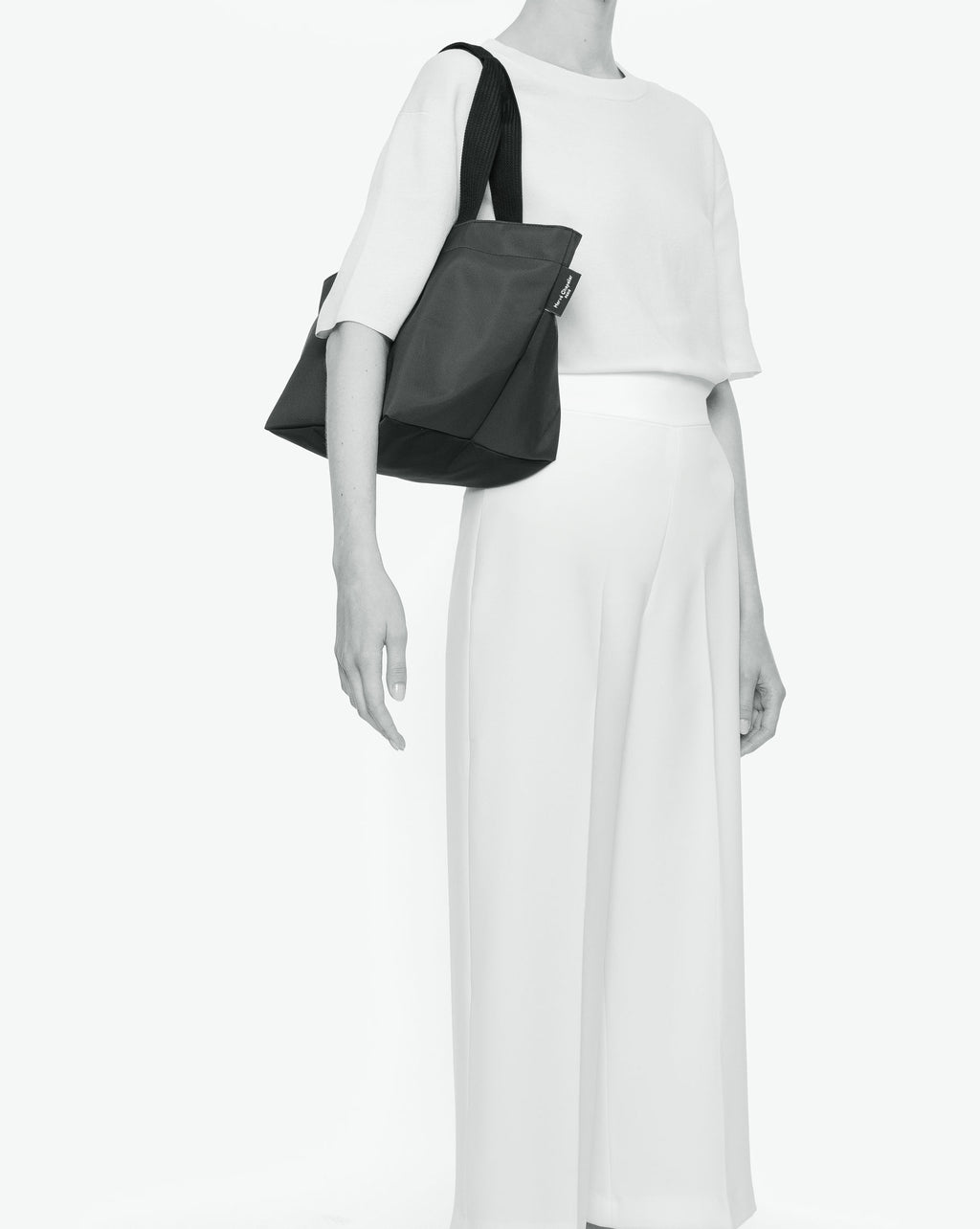 Sac cabas porté épaule de couleur en nylon bicolore, à fond carré et dans un format M. Présence d'un double zip, d'anses longues noires en polypropylène, et d'une étiquette de marque verte.