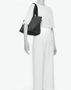 Sac cabas porté épaule de couleur en nylon bicolore, à fond carré et dans un format M. Présence d'un double zip, d'anses longues noires en polypropylène, et d'une étiquette de marque verte.