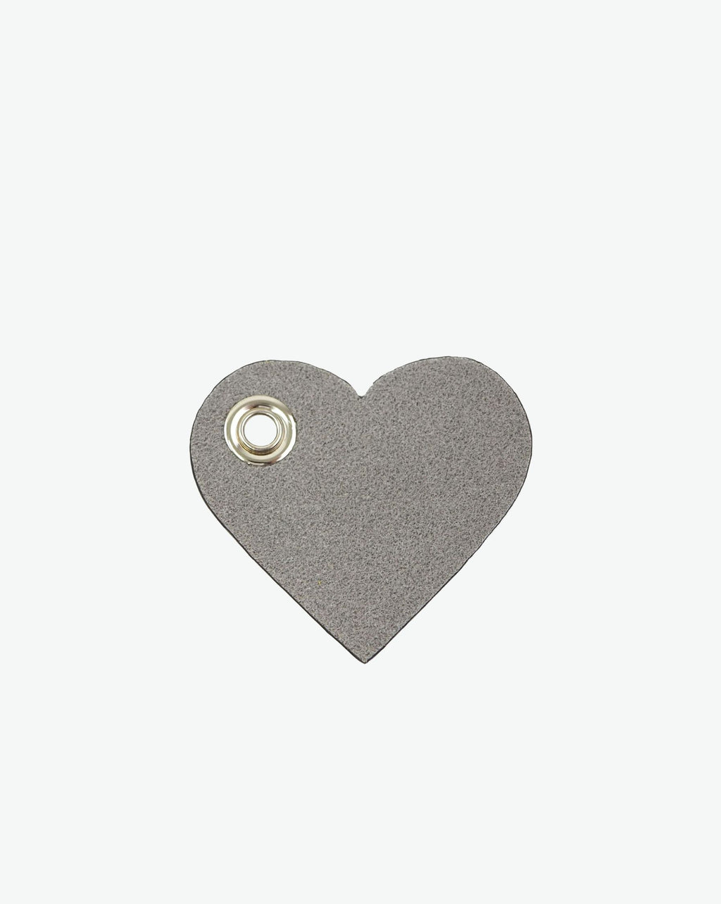 Packshot of a 122L flat charm in the shape of a heart with the Hervé Chapelier logo. The charm is made of leather with a eyelet in the middle in a XXS size. Charme en forme de coeur en cuir dans une taille XXS