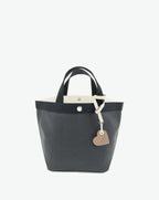 Packshot of a 122L flat charm in the shape of a heart with the Hervé Chapelier logo. The charm is made of leather with a eyelet in the middle in a XXS size. Charme en forme de coeur en cuir dans une taille XXS
