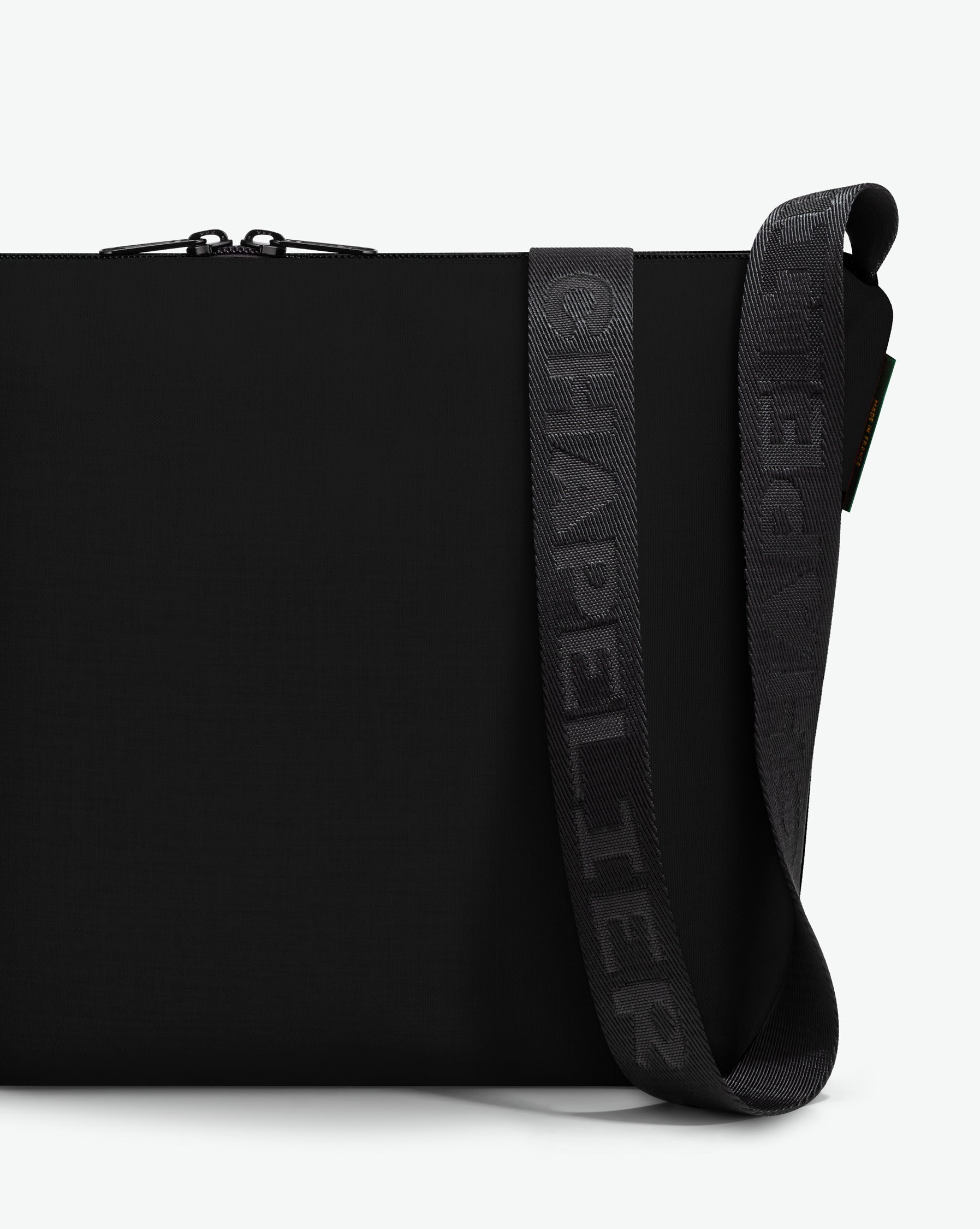 Packshot of a 1754CJQ shoulder crossbody bag with a large and long labeled “Chapelier” handle in polyamide The bag is made of solid polyamide, in a rectangular size Sac bandouliere epaule en nylon uni taille L