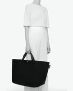 Packshot of a 1838C travel bag rectangular bottom with short polycotton handles and a zipper and an inside pocket. This extra-large bag is made of polyamide. Sac cabas a poignees courtes en polyamide uni format XL