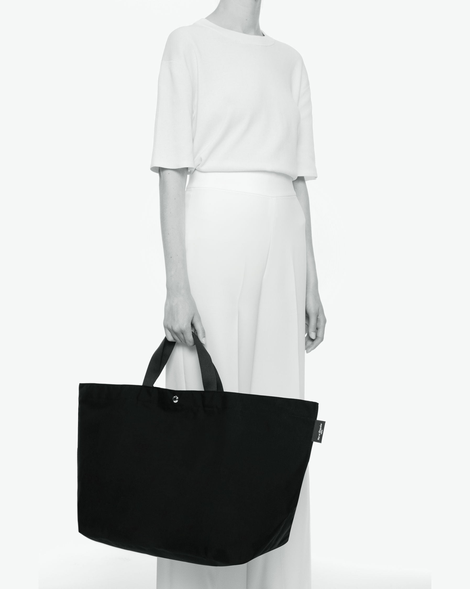 Packshot of a 1838C travel bag rectangular bottom with short polycotton handles and a zipper and an inside pocket. This extra-large bag is made of polyamide. Sac cabas a poignees courtes en polyamide uni format XL