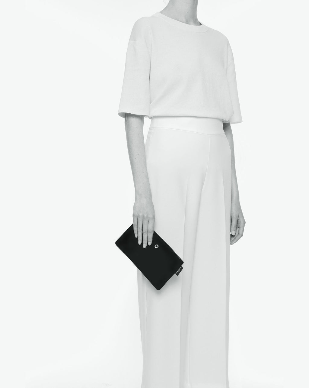 Packshot of a 1902NM rectangular flat pouch with one silver ring on a side and a metal eyelet and a zipper. The pouch is made of microfiber nylon in an XS size. Pochette plate rectangulaire satinée taille XS