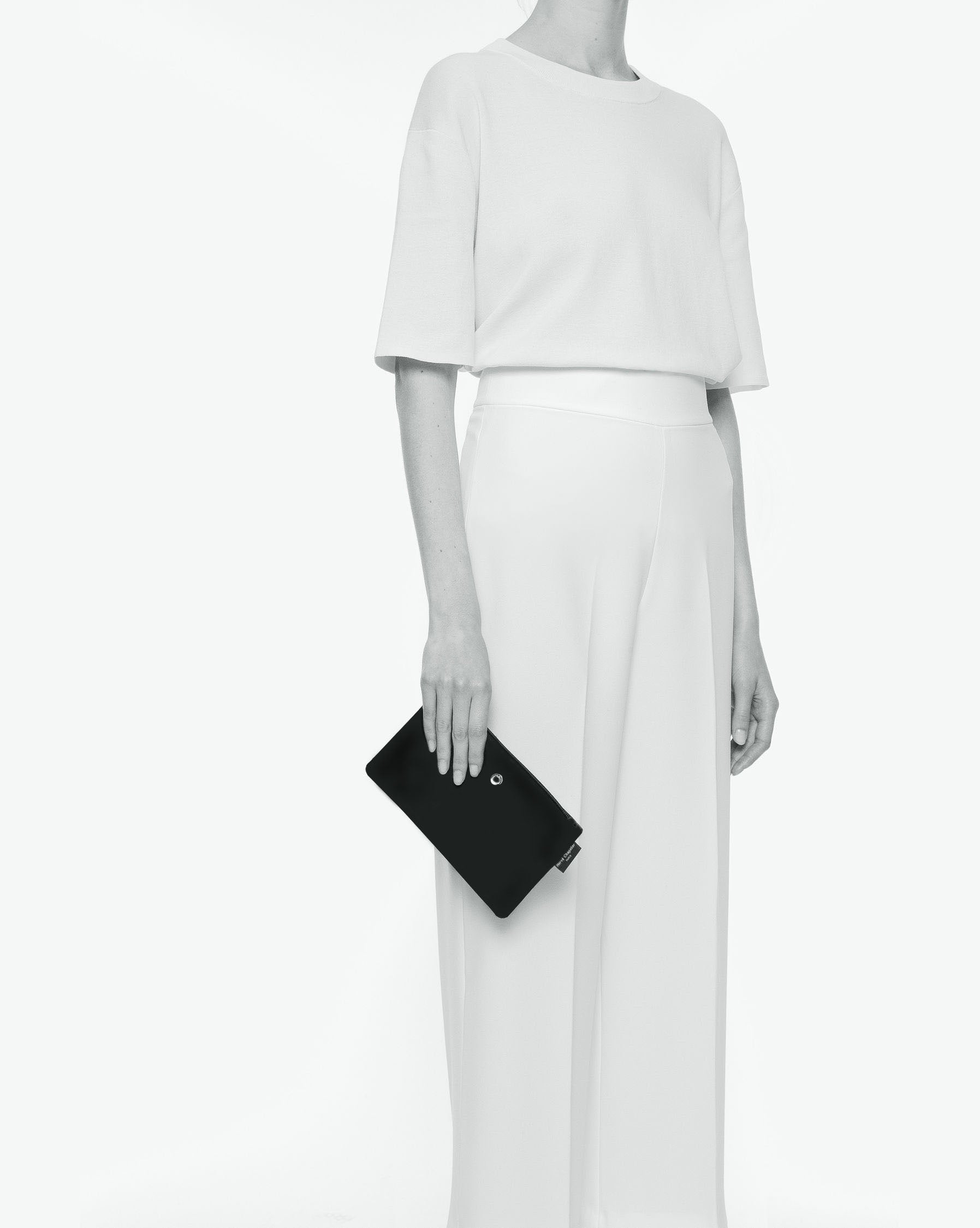 Packshot of a 1902NM rectangular flat pouch with one silver ring on a side and a metal eyelet and a zipper. The pouch is made of microfiber nylon in an XS size. Pochette plate rectangulaire satinée taille XS