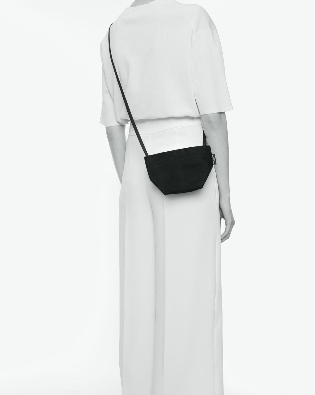 Packshot of a 1927N shoulder crossbody bag with a long handle in polyamide webbing and a zipper. The bag is made of solid nylon in an extra-small size. Mini sac bandouliere epaule fond carre uni taille XS
