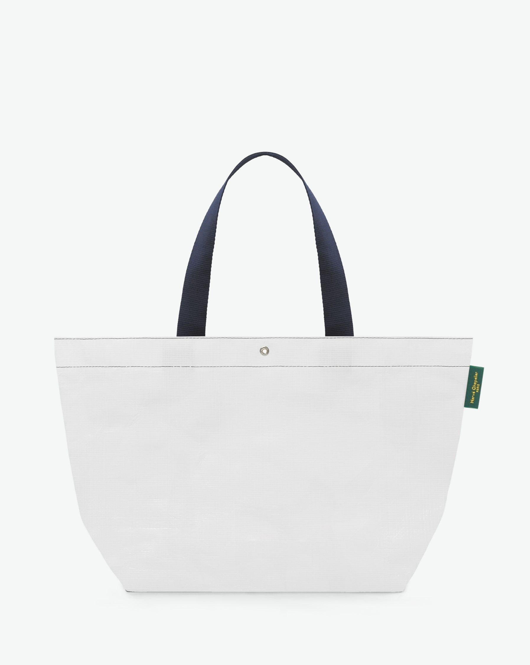 Sac cabas marché coloré en polypropylène, à fond rectangulaire et dans une taille L, aux poignées longues de couleur en polyamide et à l'œillet décoratif. Idéal pour un porté à l'épaule.