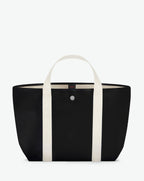 Sac à main en toile enduite grainée, à fond rectangulaire et dans une taille M, et aux poignées courtes de couleur à l'aspect coton faisant le tour du sac.