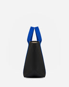 Sac à main en toile enduite grainée, à fond rectangulaire et dans une taille M, et aux poignées courtes de couleur à l'aspect coton faisant le tour du sac.
