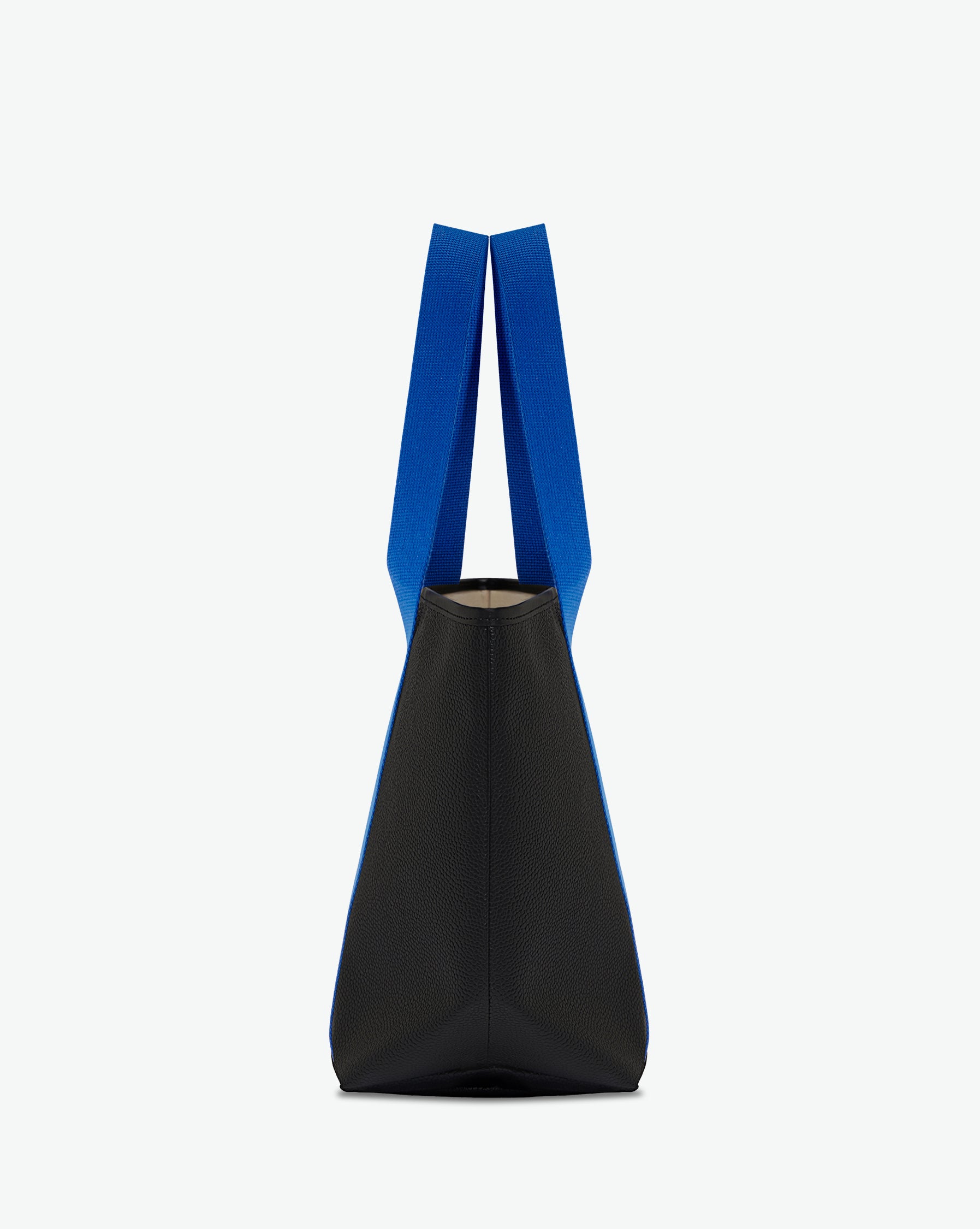 Sac porté épaule en toile enduite grainée, à fond rectangulaire et dans une taille M, et aux poignées longues de couleur à l'aspect coton faisant le tour du sac.