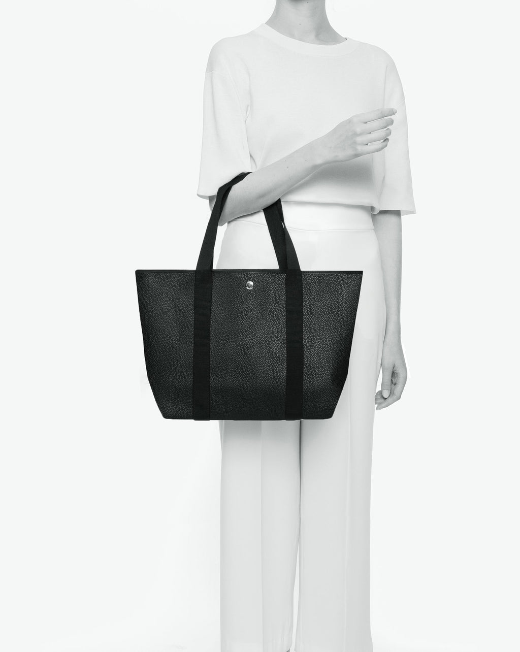 Sac porté épaule en toile enduite grainée, à fond rectangulaire et dans une taille M, et aux poignées longues de couleur à l'aspect coton faisant le tour du sac.