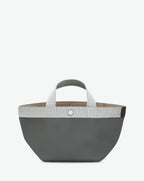 Sac à main en toile enduite grainée en taille S, au fond carré et aux poignées courtes de couleur à l'aspect coton, ainsi qu'à la poche intérieure avec bouton pression.