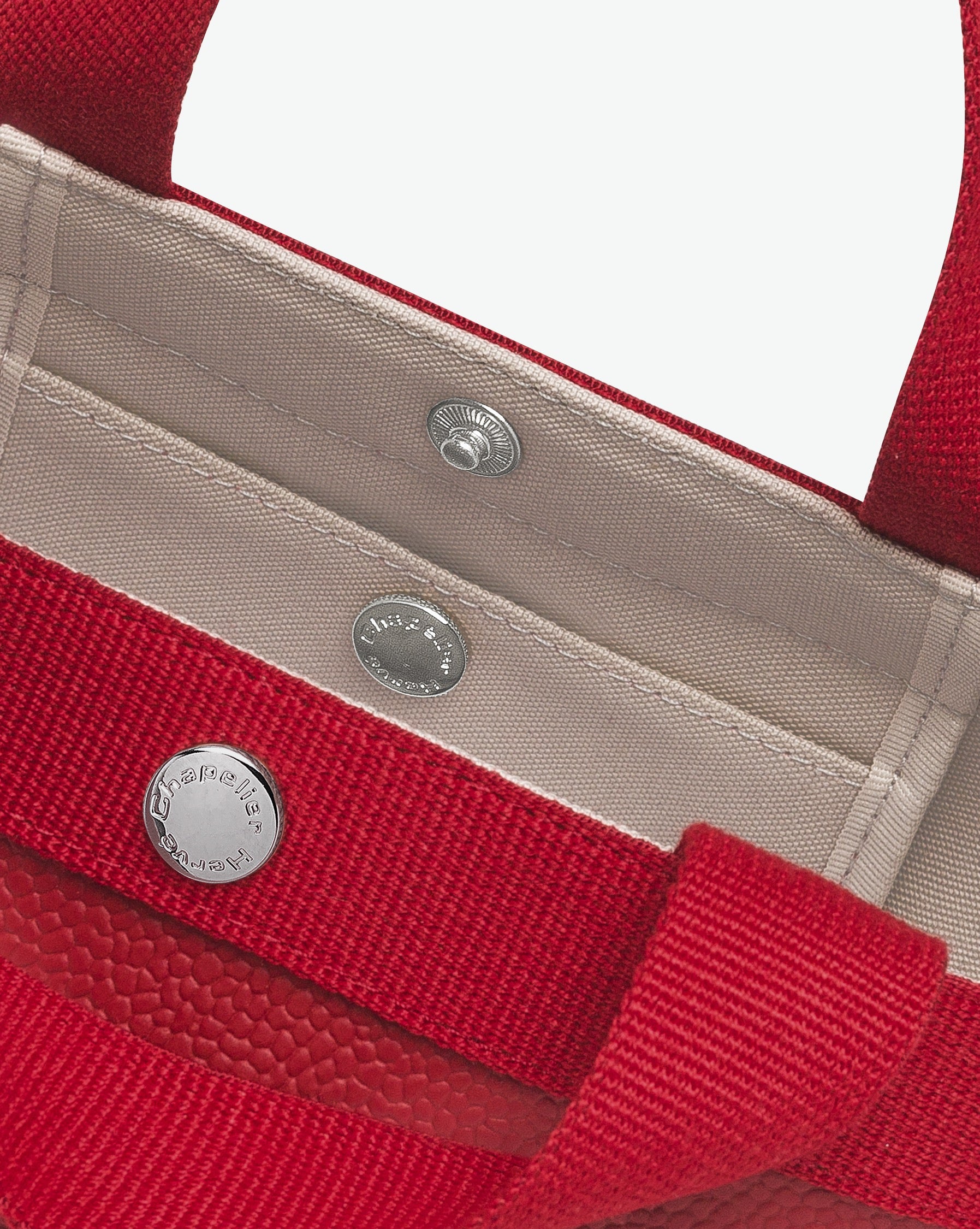 Sac à main en toile enduite grainée en taille S, au fond carré et aux poignées courtes de couleur à l'aspect coton, ainsi qu'à la poche intérieure avec bouton pression.