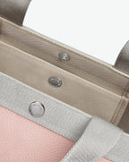 Sac à main en toile enduite grainée en taille S, au fond carré et aux poignées courtes de couleur à l'aspect coton, ainsi qu'à la poche intérieure avec bouton pression.