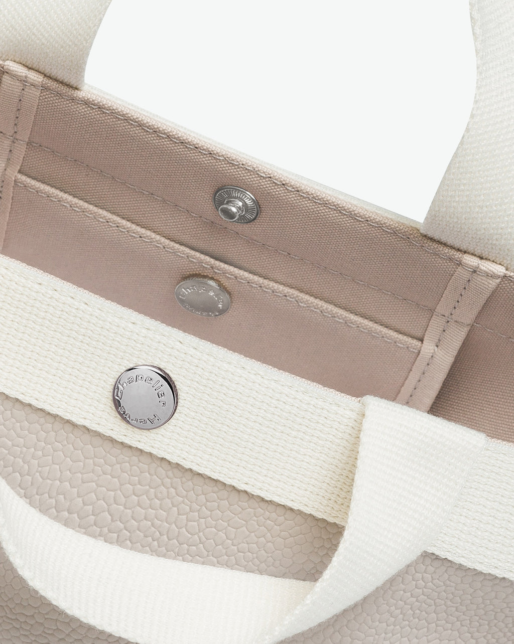 Sac à main en toile enduite grainée en taille S, au fond carré et aux poignées courtes de couleur à l'aspect coton, ainsi qu'à la poche intérieure avec bouton pression.