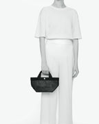 Sac à main en toile enduite grainée en taille S, au fond carré et aux poignées courtes de couleur à l'aspect coton, ainsi qu'à la poche intérieure avec bouton pression.
