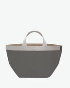 Sac à main en toile enduite grainée en taille M, au fond carré et aux poignées courtes de couleur à l'aspect coton, ainsi qu'à la poche intérieure avec bouton pression.