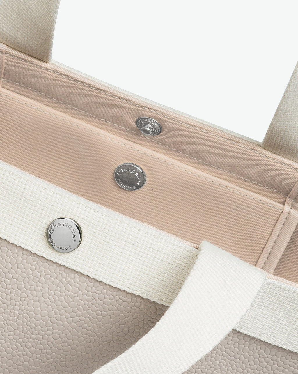 Sac à main en toile enduite grainée en taille M, au fond carré et aux poignées courtes de couleur à l'aspect coton, ainsi qu'à la poche intérieure avec bouton pression.