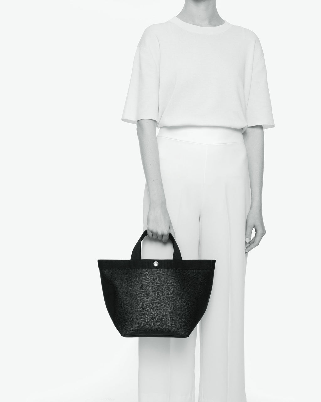 Sac à main en toile enduite grainée en taille M, au fond carré et aux poignées courtes de couleur à l'aspect coton, ainsi qu'à la poche intérieure avec bouton pression.