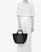 Sac à main en toile enduite grainée en taille M, au fond carré et aux poignées courtes de couleur à l'aspect coton, ainsi qu'à la poche intérieure avec bouton pression.