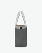 Sac à main en toile enduite grainée en taille L, au fond rectangulaire et aux poignées longues de couleur à l'aspect coton, ainsi qu'à la poche intérieure avec bouton pression.