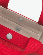 Sac à main en toile enduite grainée en taille L, au fond carré et aux poignées longues de couleur à l'aspect coton, ainsi qu'à la poche intérieure avec bouton pression.