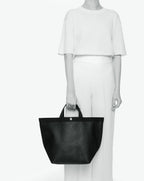 Sac à main en toile enduite grainée en taille L, au fond carré et aux poignées longues de couleur à l'aspect coton, ainsi qu'à la poche intérieure avec bouton pression.