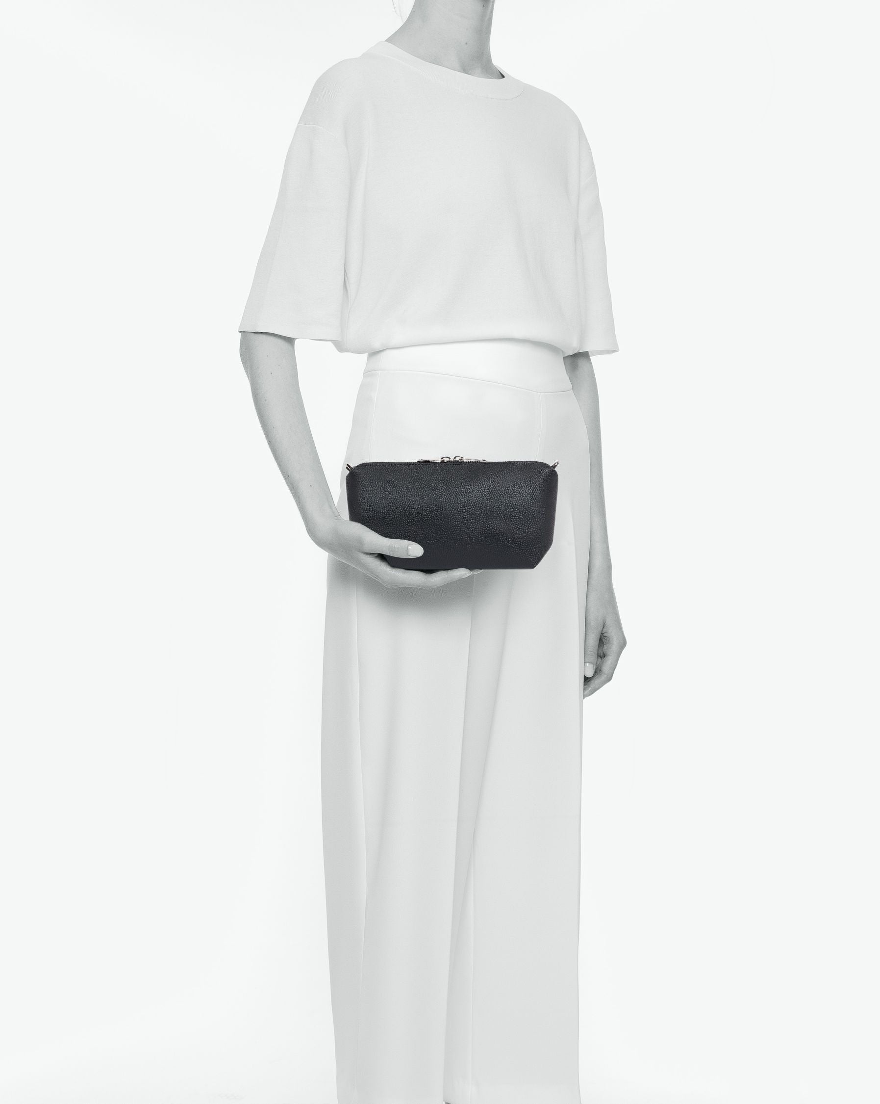 Packshot of a 8784G clutch bag pouch rectangular with a zipper and 2 rings in a small size. The tote is made of pebbled grain coated canvas. Sac pochette rectangulaire toile enduite dans une taille S