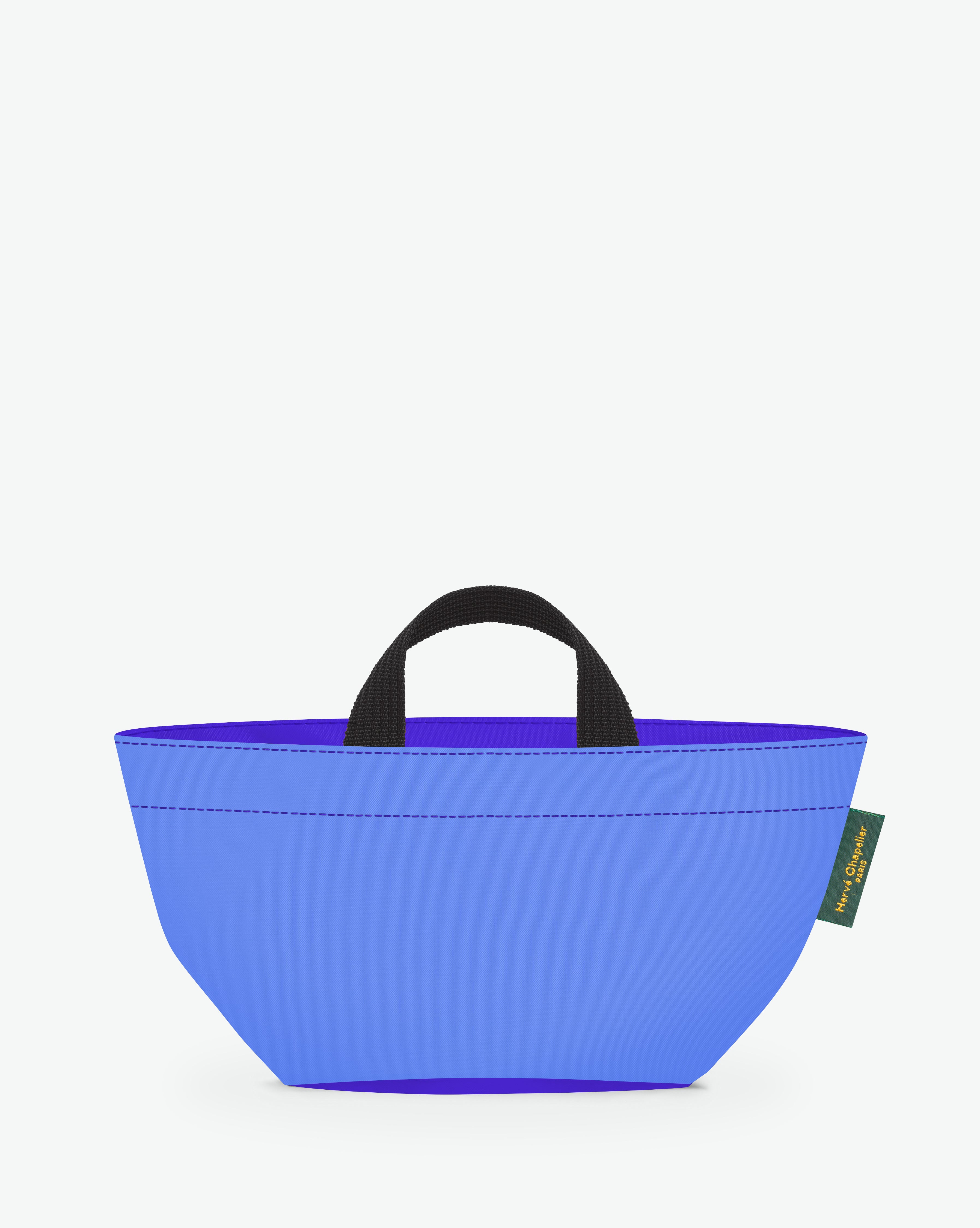 Sac à main cabas de couleur en nylon bicolore, à fond carré et dans un format S. Présence d'un double zip, de poignées courtes noires en polypropylène, et d'une étiquette de marque verte.