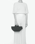Sac à main cabas de couleur en nylon bicolore, à fond carré et dans un format S. Présence d'un double zip, de poignées courtes noires en polypropylène, et d'une étiquette de marque verte.