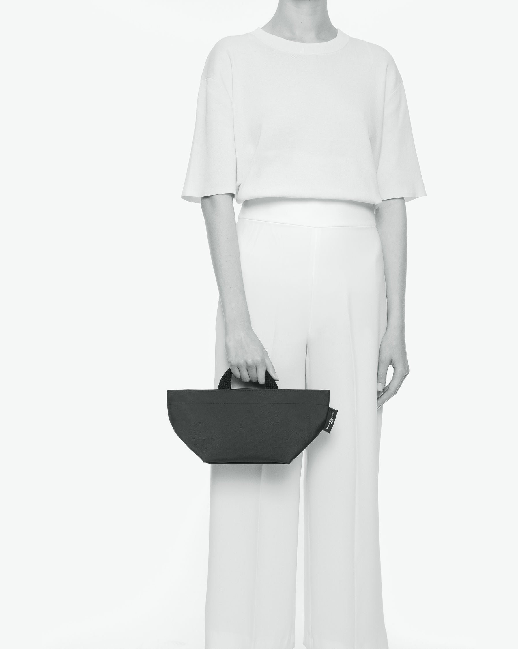 Sac à main cabas de couleur en nylon bicolore, à fond carré et dans un format S. Présence d'un double zip, de poignées courtes noires en polypropylène, et d'une étiquette de marque verte.