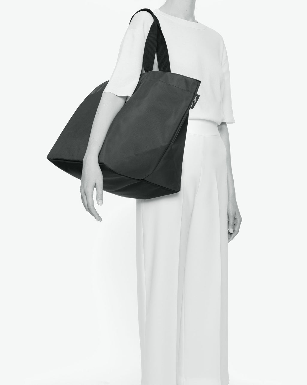 Sac cabas porté épaule de couleur en nylon bicolore, à fond carré et dans un format XL. Présence d'un double zip, d'anses longues noires en polypropylène, et d'une étiquette de marque verte.