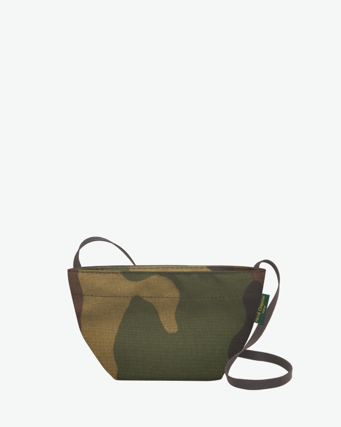Visual on a white background of a shoulder bag standing upright and straight, with a long handle and a zip with double closure. The bag is made from printed nylon fabric in a camouflage motif. The Hervé Chapelier label is affixed to the left-hand side.