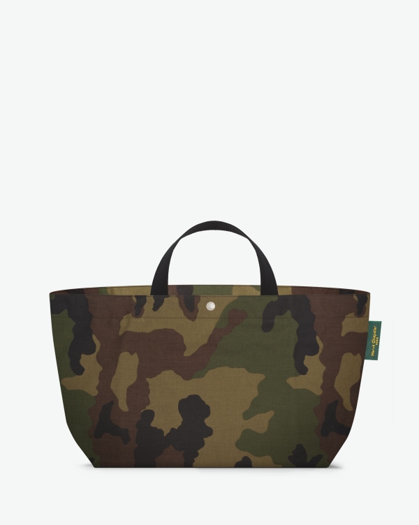 Hervé Chapelier -  - Visual on a white background of a large tote bag standing upright and straight, with short polycotton handles, a zipper and an inside pocket. The bag is made from printed polyamide fabric in a camouflage forêt noir motif. The Hervé Chapelier label is affi