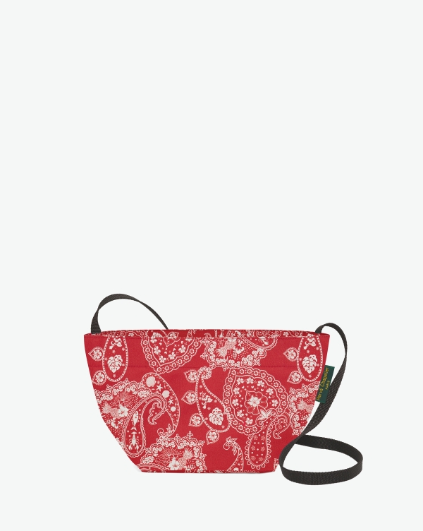 Hervé Chapelier -  - Visual on a white background of a shoulder bag standing upright and straight, with a long handle and a zip with double closure. The bag is made from printed nylon fabric in a bandana rouge motif. The Hervé Chapelier label is affixed to the left-hand side.